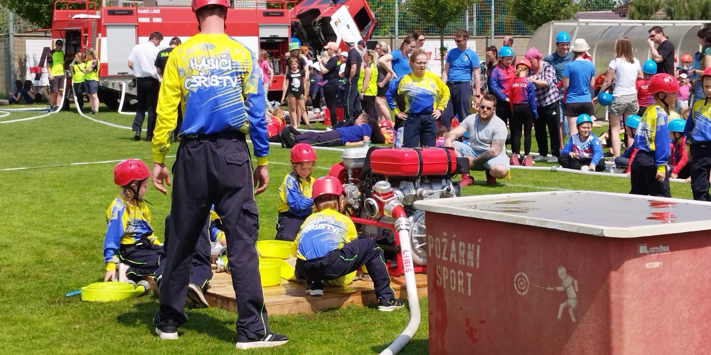 Dětská hasičská soutěž v Obříství s hasiči a diváky na místním hřišti